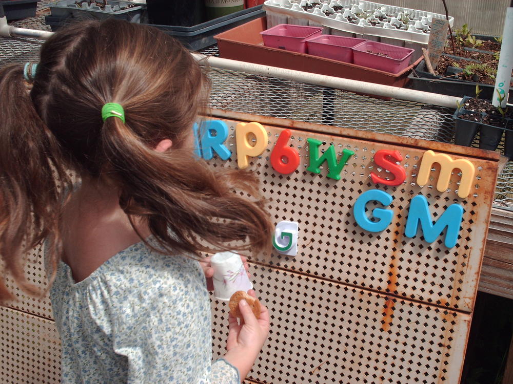 A girl placing letters on a peg board